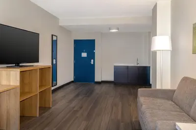 a living room with a couch and a flat screen tv at Spark By Hilton Montreal Midtown in Montréal