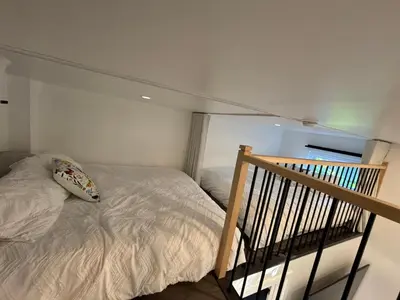 a bedroom with a bed and a stair railing at Spa - Chalet Sur Les Sentiers du Pic-Bois in Adstock