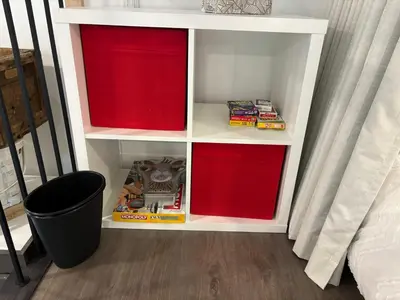 a white book shelf with red inside of it at Spa - Chalet Sur Les Sentiers du Pic-Bois in Adstock