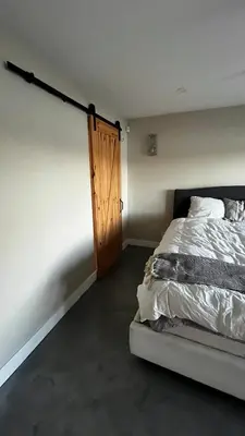 a bedroom with a bed and a wooden door at Cozy Riverside Home Retreat in Laval