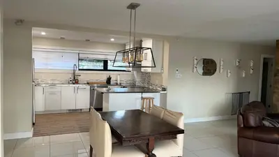 a kitchen with a table and a dining room at Cozy Riverside Home Retreat in Laval