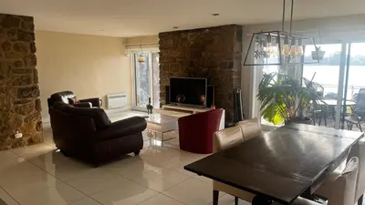 a living room with a couch and a table and a television at Cozy Riverside Home Retreat in Laval