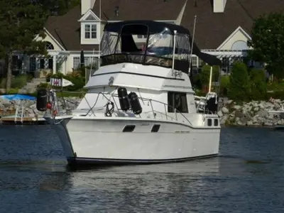 a white boat in the water in front of a house at Chalet Boat in the heart of Montreal in Montréal
