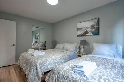 a bedroom with two beds and a mirror at 3BR 6Beds 5min Walk Metro Free Parking Place Bell in Laval