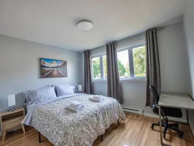 a bedroom with a bed and a desk and windows at 3BR 6Beds 5min Walk Metro Free Parking Place Bell in Laval