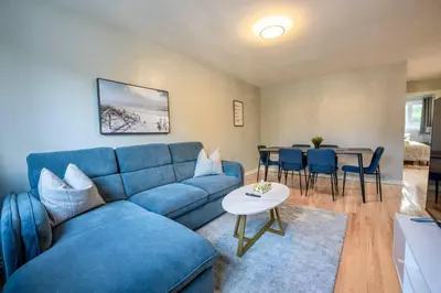 a living room with a blue couch and a table at 3BR 6Beds 5min Walk Metro Free Parking Place Bell in Laval
