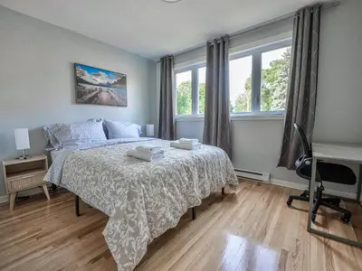 a bedroom with a bed and a desk and windows at 3BR 6Beds 5min Walk Metro Free Parking Place Bell in Laval
