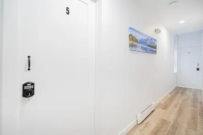 a room with white walls and a door with a picture at Room 1 - apartment 2 in a SHARED apartment in Montréal