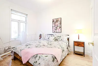 a white bedroom with a bed and a window at Royal Level-5 bedrooms avec 2 places de parking in Montréal