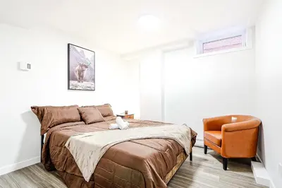 a bedroom with a bed and a chair at Royal Level-5 bedrooms avec 2 places de parking in Montréal