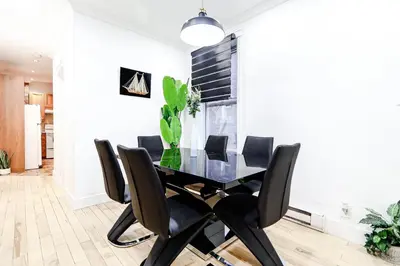 a dining room with a black table and black chairs at Royal Level-5 bedrooms avec 2 places de parking in Montréal