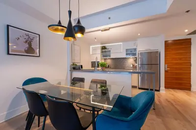 a dining room with a glass table and blue chairs at Modern Condo Old Town Montreal in Montréal
