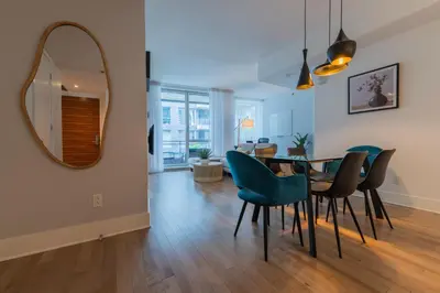 a dining room with a table and chairs and a mirror at Modern Condo Old Town Montreal in Montréal