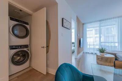 a living room with a washing machine and a glass table at Modern Condo Old Town Montreal in Montréal