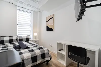 a white bedroom with a black and white bed and a desk at Chambre 2 - appartement 2 dans un appartement PARTAGÉ in Montréal