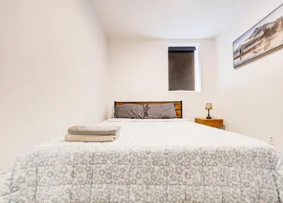 a white bedroom with a bed and a window at Séjour agréable à Griffintown 2 chambres in Montréal