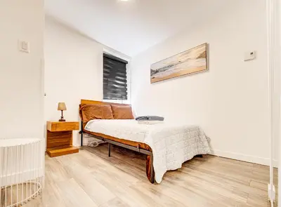 a white bedroom with a bed and a window at Séjour agréable à Griffintown 2 chambres in Montréal