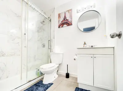 a white bathroom with a shower and a toilet at Séjour agréable à Griffintown 2 chambres in Montréal