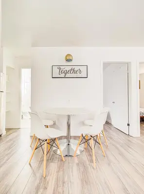 a white dining room with a table and chairs at Chic & spacieux 2 chambres à Griffintown in Montréal