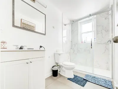 a white bathroom with a shower and a toilet at Chic & spacieux 2 chambres à Griffintown in Montréal