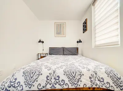 a bedroom with a bed with a blue and white comforter at Chic & spacieux 2 chambres à Griffintown in Montréal