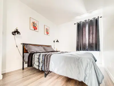a white bedroom with a bed and a window at Chic & spacieux 2 chambres à Griffintown in Montréal