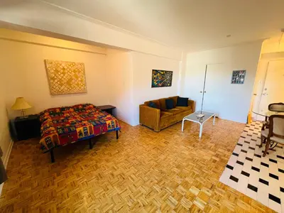 a bedroom with a bed and a couch in a room at Modern City Living in the Golden Square Mile in Montréal