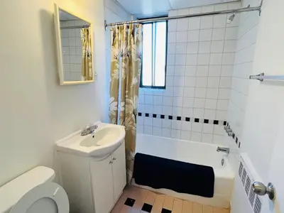 a bathroom with a sink and a toilet and a bath tub at Modern City Living in the Golden Square Mile in Montréal