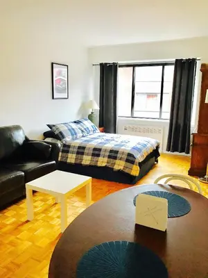 a living room with a bed and a couch at Modern City Living in the Golden Square Mile in Montréal