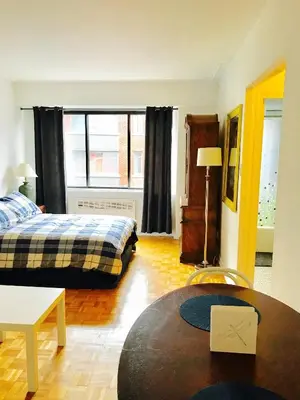 a room with two beds and a table in it at Modern City Living in the Golden Square Mile in Montréal