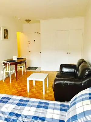 a living room with a black leather couch and a table at Modern City Living in the Golden Square Mile in Montréal