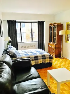 a living room with a bed and a couch at Modern City Living in the Golden Square Mile in Montréal