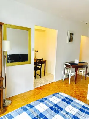 a room with a bed and a table and a mirror at Modern City Living in the Golden Square Mile in Montréal