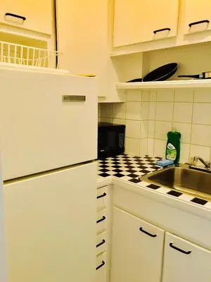 a white kitchen with a sink and a stove at Modern City Living in the Golden Square Mile in Montréal