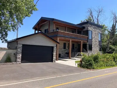 a large house with a garage and a house at Modern apartment with magnificent views in Vaudreuil-Dorion