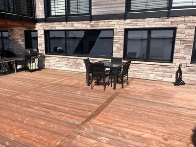 a wooden deck with a table and chairs on it at Modern apartment with magnificent views in Vaudreuil-Dorion