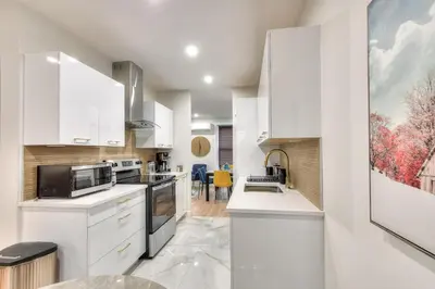 a kitchen with white cabinets and a counter top at Stylish Condo AC Wi-Fi Westmount Smart TV in Montréal