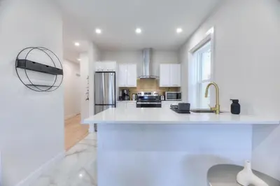 a white kitchen with a sink and a refrigerator at Stylish Condo AC Wi-Fi Westmount Smart TV in Montréal