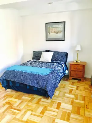 a bedroom with a bed and a wooden floor at Modern Apartment City Living in the Golden Square Mile in Montréal