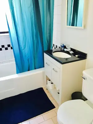 a bathroom with a blue shower curtain and a sink at Modern Apartment City Living in the Golden Square Mile in Montréal