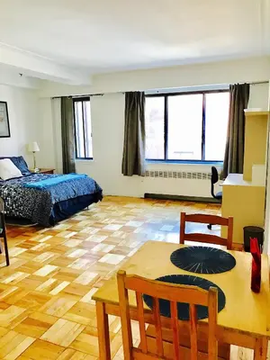 a bedroom with a bed and a table in a room at Modern Apartment City Living in the Golden Square Mile in Montréal