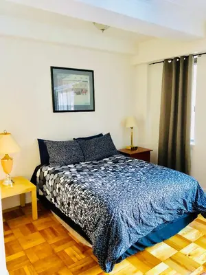 a bedroom with a bed with a blue comforter at Modern Apartment City Living in the Golden Square Mile in Montréal