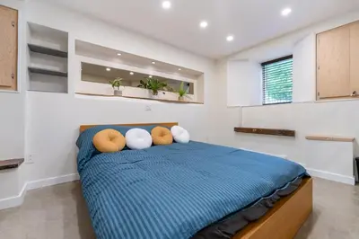 a bedroom with a bed with pillows on it at une retraite de qualité au niveau du jardin en centre-ville in Montréal