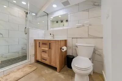a bathroom with a toilet and a shower and a sink at une retraite de qualité au niveau du jardin en centre-ville in Montréal
