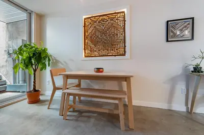 a table and chair in a room with a plant at une retraite de qualité au niveau du jardin en centre-ville in Montréal