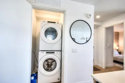 a washer and dryer in a room with a mirror at Tiny Penthouse Big Balcony Central & Cozy in Montréal