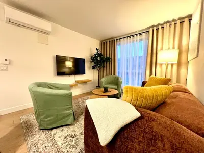 a living room with a couch and chairs and a tv at Tiny Penthouse Big Balcony Central & Cozy in Montréal