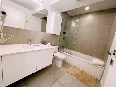a bathroom with a sink and a toilet and a shower at Tiny Penthouse Big Balcony Central & Cozy in Montréal