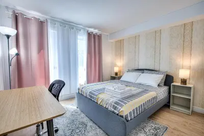 a small bedroom with a bed and a table at Tiny Penthouse Big Balcony Central & Cozy in Montréal