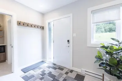 a hallway with a door and a potted plant at Chalet Mid-Century - Lakeside Joseph - Le Charlo in Saint-Pierre-Baptiste